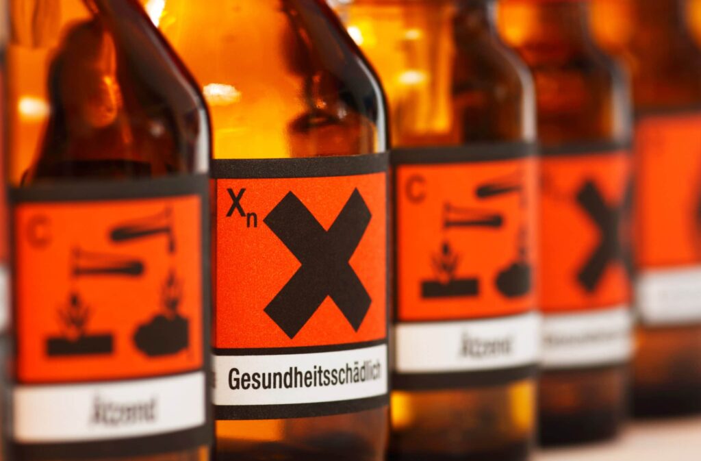 Gefahrstoffverordnung – Chemikalienflaschen mit Gefahrstoffkennzeichnung als Symbol für den sicheren Umgang mit Gefahrstoffen